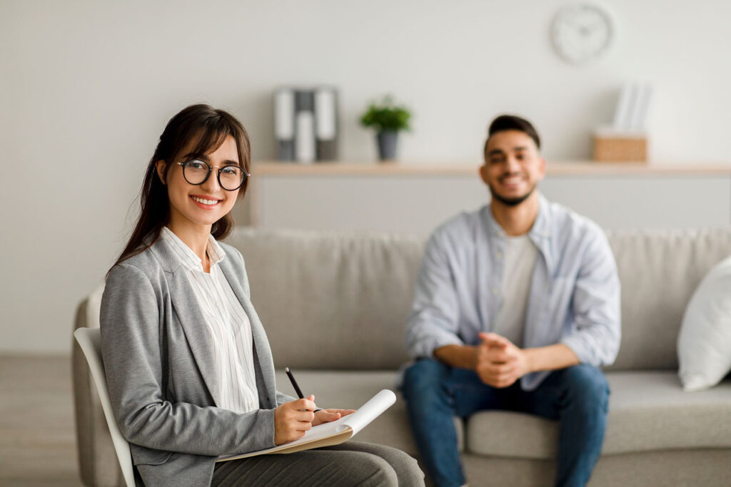 smiling therapist engaged with young male patient who wants to know what is dialectical behavior therapy