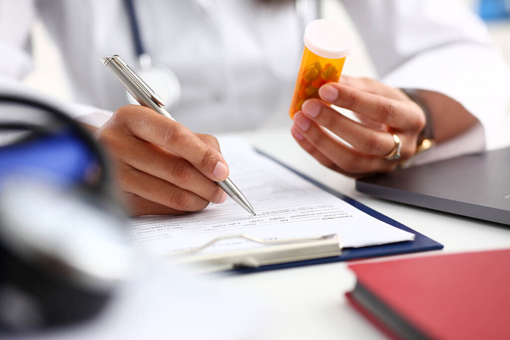 a doctor writes a prescription for naltrexone treatment