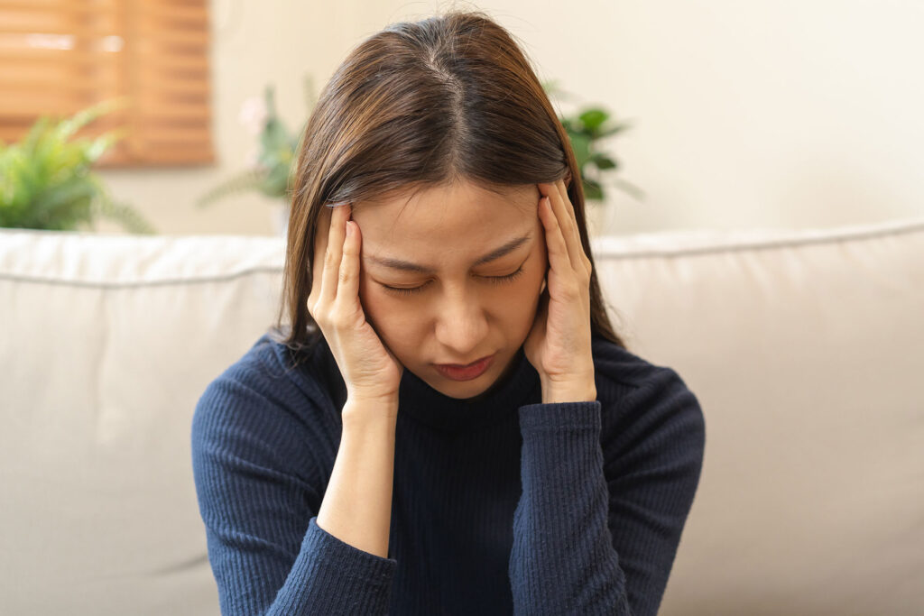 woman with head in hands considering the effects of opioid addiction