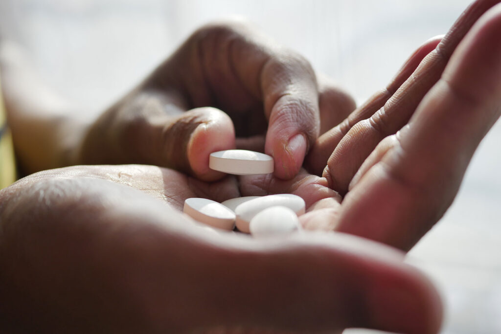 person picking up oxycontin pill and wondering about oxycontin abuse