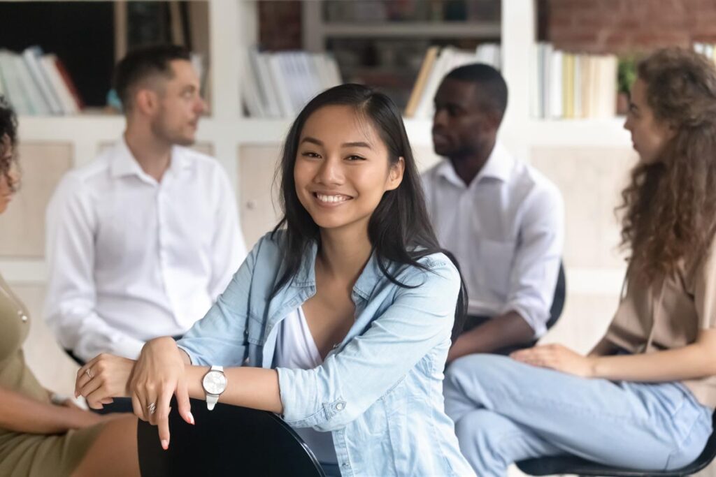 woman in denim shirt smiling in a group therapy program