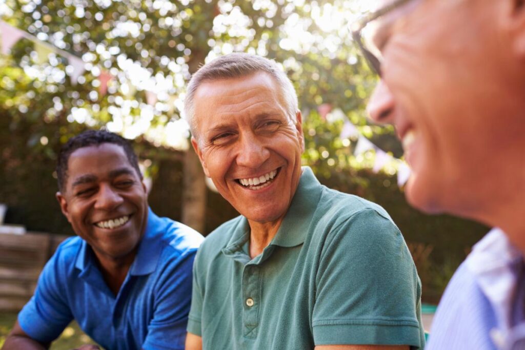 men outside in the shade discussing a mens rehab center