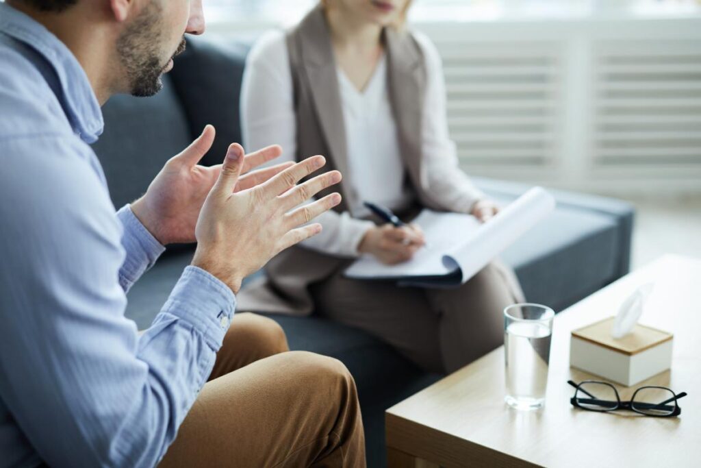 woman in vest talking with man in blue shirt about how to detox from alcohol